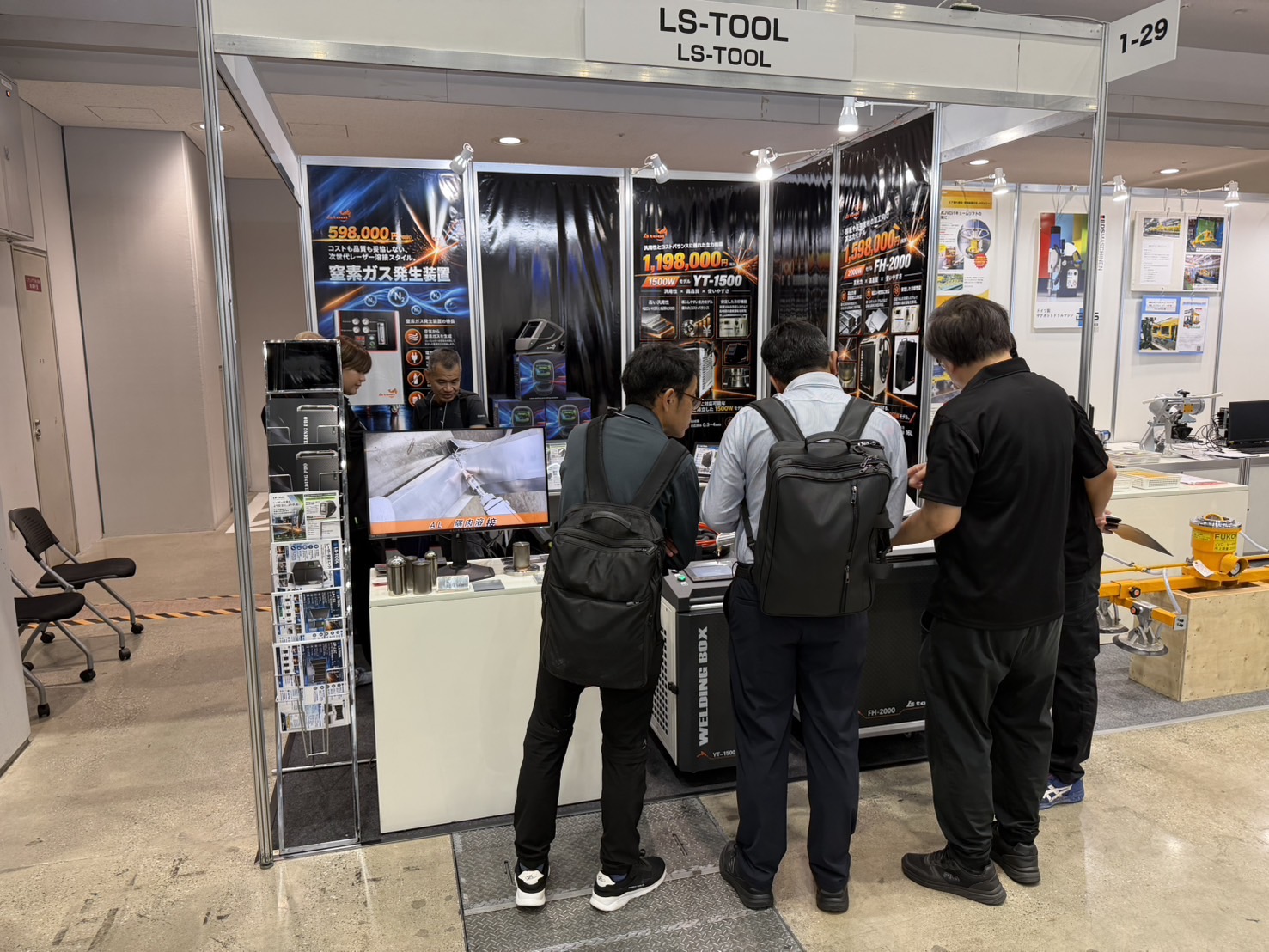 LS-TOOLの実機や展示資料をご覧になる来場者とスタッフ